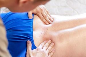Ein Mann wird mit Akupunktur auf dem Rücken behandelt. das Akupunkturverfahren. Rückenbehandlung foto
