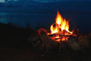 Nahaufnahme eines Lagerfeuers im Freien, das nachts hell brennt. foto