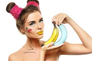 schönes Modell mit kreativem Pop-Art-Make-up, das Bananen hält