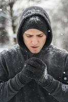 Schöner sportlicher Mann mit Hoodie während seines Wintertrainings foto