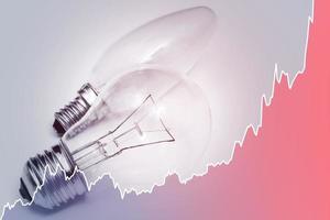 Glühbirnen und steigendes Diagramm, das den aktuellen Strompreis während der Energiekrise in der Welt darstellt foto