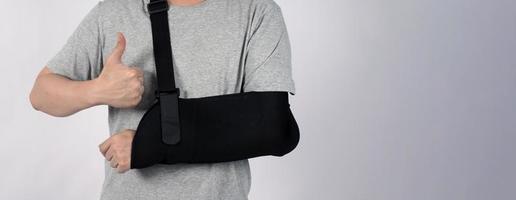 gebrochener Arm. Armschlingentherapieunterstützung und bedeckt um den ersten Knöchel des Ellbogens gebrochener Arm. foto