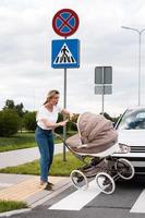 Mutter auf dem Zebrastreifen nach einem Autounfall, als ein Fahrzeug ihren Kinderwagen trifft. foto
