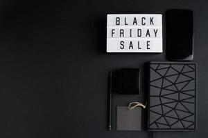 Black Friday Online-Verkaufskonzept. einfarbiges Flatlay auf dunklem Hintergrund. Smartphone und Zubehör. foto