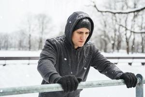 athletischer Mann, der während seines Calisthenics-Wintertrainings Liegestütze macht foto