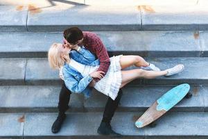 Teenagerpaar sitzt und küsst sich auf einer Betontreppe foto