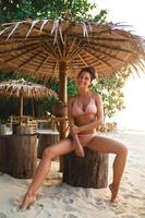 sexy Frau mit Bikini sitzt in der Strandbar foto