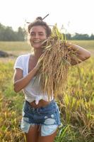 glückliche Bäuerin während der Ernte auf dem Reisfeld foto