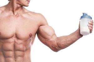 muskulöser Bodybuilder mit einem Shaker voller Molkenprotein foto