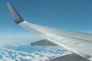 Blick vom Flugzeugfenster auf Flügel und Himmel mit Wolken foto