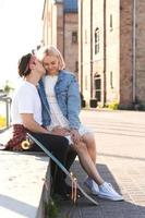 Teenager-Paar mit einem Longboard bei ihrem Date in einer Stadt foto