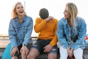 Drei positive Freunde lachen auf einer Straße foto