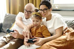 Glückliche Familie spielt zu Hause eine Videospielkonsole foto