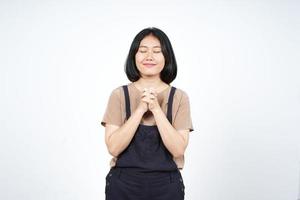 Faltende Hand geschlossenes Auge und beten der schönen asiatischen Frau, die auf weißem Hintergrund lokalisiert wird foto