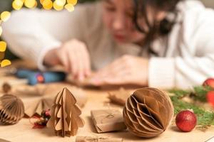 Mädchen macht Christbaumschmuck aus Papier mit ihren eigenen Händen. Schritt-für-Schritt-Anleitung foto