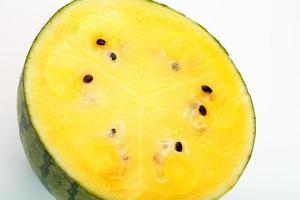 eine halbe saftige, gelbe wassermelone auf weißem hintergrund, textur aus saftigem fruchtfleisch und mesmes aus reifer wassermelone foto