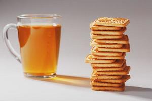 Weizenkekse und eine Tasse grüner Tee im Inneren auf hellem Hintergrund, weicher Kontrast. Im Frühstücksraum liegen Kekse bereit foto