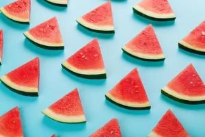 Muster von Scheiben frischer Scheiben roter und gelber Wassermelone auf blauem Hintergrund. Ansicht von oben foto