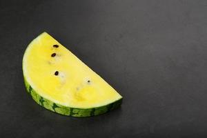 scheiben der gelben wassermelone auf einem rosa hintergrund in der form. minimale lebensmittelkonzeptidee. flach liegen foto