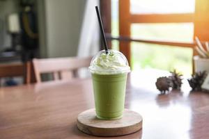 Grüntee-Smoothie - Matcha-Grüntee mit Milch auf Plastikglas, serviert in einem Café foto