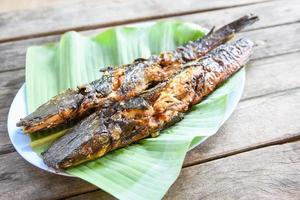 auf Bananenblatt gerösteter Wels - gekochter Wels gegrilltes asiatisches Essen auf Holztisch foto