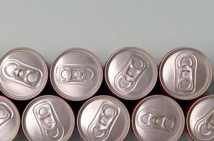 viele neue Aluminiumdosen von Soda-Softdrink- oder Energy-Drink-Behältern. Getränkeherstellungskonzept und Massenproduktion foto