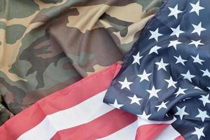 Flagge der Vereinigten Staaten von Amerika und gefaltete Militäruniformjacke. militärische symbole konzeptioneller hintergrundbanner für amerikanische patriotische feiertage foto