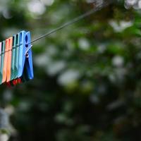 Wäscheklammern an einem Seil, das außerhalb des Hauses und des Apfelbaums hängt foto