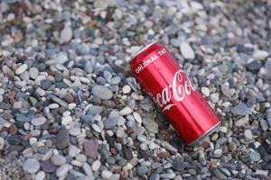 antalya, türkei - 18. mai 2022 originale rote blechdose von coca cola liegt auf kleinen runden kieselsteinen in der nähe der meeresküste. Coca-Cola am türkischen Strand foto