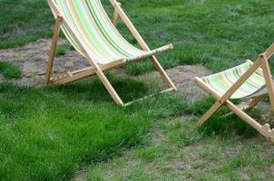 Liegestühle auf einer Wiese. Gartenliegen auf grünem Gras foto