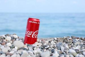 antalya, türkei - 18. mai 2022 originale rote blechdose von coca cola liegt auf kleinen runden kieselsteinen in der nähe der meeresküste. Coca-Cola am türkischen Strand foto