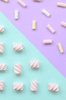 bunter Marshmallow auf violettem und blauem Papierhintergrund. pastellfarbenes, kreatives Strukturmuster. minimal foto