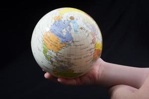 Hand, die einen Globus mit der Karte darauf hält foto