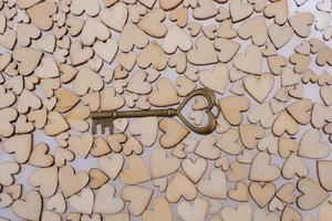 Retrostilschlüssel auf hölzernen Herzen auf weißem Hintergrund foto