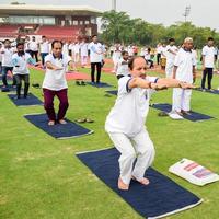 neu-delhi, indien, 21. juni 2022 - gruppen-yoga-übungssitzung für menschen im yamuna-sportkomplex in delhi am internationalen yoga-tag, große gruppe von erwachsenen, die an yoga-kursen im cricket-stadion teilnehmen