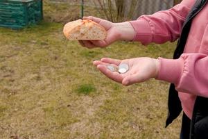 letztes Geld für Brot. Brot in der Hand einer Frau mittleren Alters. das Konzept der Welternährungskrise im Zusammenhang mit dem Krieg in der Ukraine foto