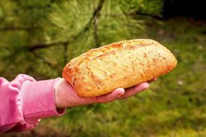 Brot in der Hand einer Frau mittleren Alters. das Konzept der Welternährungskrise im Zusammenhang mit dem Krieg in der Ukraine foto