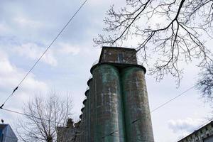 Kornelevator gegen einen stürmischen Himmel. Große Fabrikstruktur vor blauem Himmel, niedrige Winkelansicht. foto