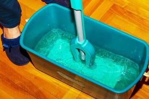 Wischen Sie Ihren Holzboden. Eine Frau bereitet einen Mopp vor. Housekeeping-Konzept. foto