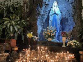 die höhle der jungfrau maria, statue der jungfrau maria in einer felshöhle kapelle katholische kirche mit tropischer vegetation foto