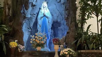 die höhle der jungfrau maria, statue der jungfrau maria in einer felshöhle kapelle katholische kirche mit tropischer vegetation foto