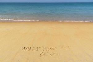 Frohes neues Jahr handschriftlich am Strand foto