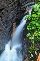 Kleiner Wasserfall in einer Schlucht in Österreich mit langer Belichtung, der glattes Wasser verursacht foto