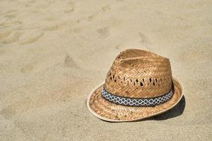 Strandhut aus Stroh für Herren auf dem Sand am Strand, Nahaufnahme, Platz für Text kopieren. ein schöner sonniger Tag. Urlaub, Sommerkonzept foto