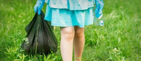 kleines Mädchen mit zerknitterter Plastikflasche foto