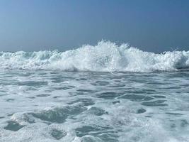 Wunderschönes Meer mit Wellen, die warmes, funkelndes, klares blaues Wasser in einem warmen, tropischen, orientalischen Land im Süden spritzen. Hintergrund, Textur foto