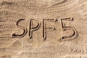 Sonnenschutzfaktor-fünf-Konzept. spf 5 Wort am Strand geschrieben foto