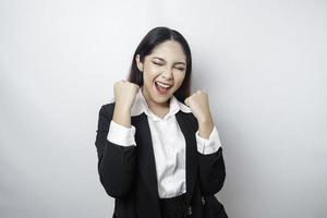 eine junge asiatische geschäftsfrau mit einem glücklichen erfolgreichen ausdruck, der schwarzen anzug trägt, der durch weißen hintergrund getrennt wird foto