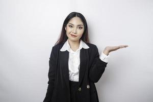 Ein Porträt einer asiatischen Chefin, die einen schwarzen Anzug trägt, sieht zwischen den Entscheidungen so verwirrt aus, isoliert durch einen weißen Hintergrund foto