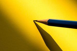 Bleistift hält, um im Schatten auf das Papier zu schreiben foto